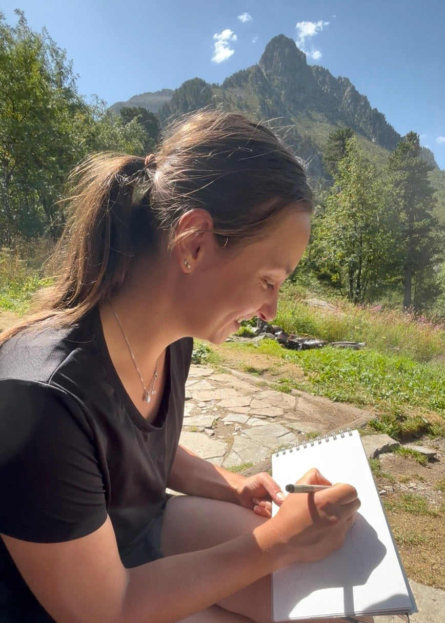 Image de Coline Pratviel en train de dessiner face à la montagne dans la vallée de Cauterets 
