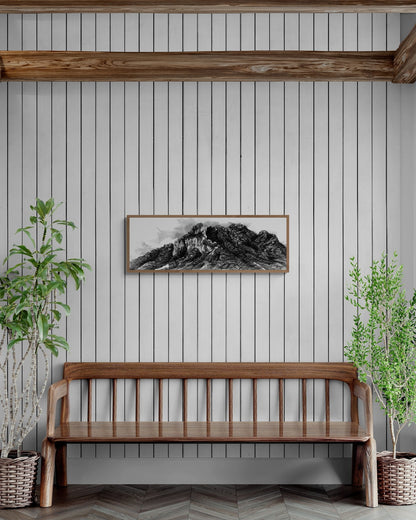 La peinture en noir et blanc peinte à l'encre de chine d'une montagne emblématique de la vallée d'Arbas est encadrée au dessus d'un banc et est entourée d'arbres 