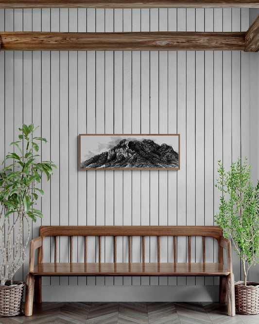 La peinture en noir et blanc peinte à l'encre de chine d'une montagne emblématique de la vallée d'Arbas est encadrée au dessus d'un banc et est entourée d'arbres 