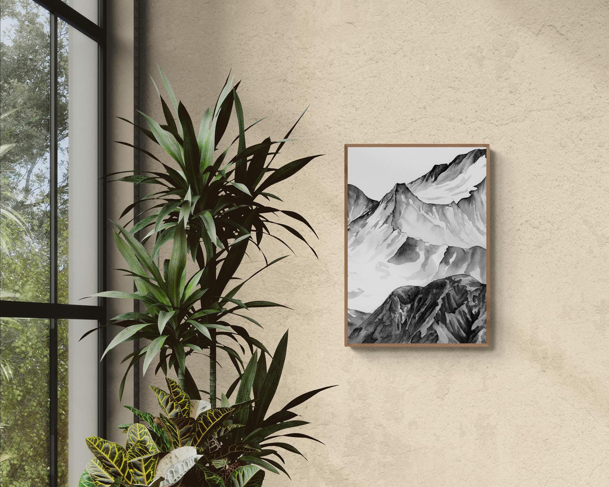 Peinture du Massif du Mont Blanc à l'encre de chine en noir et blanc au format A3 affiché dans un salon lumineux à l ambiance naturelle devant une fenêtre et des plantes pour une décoration d'intérieure naturelle, chaleureuse et cosy sublimant la décoration